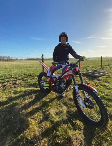 Alicia Robinson sits on her motocross bike in the countryside