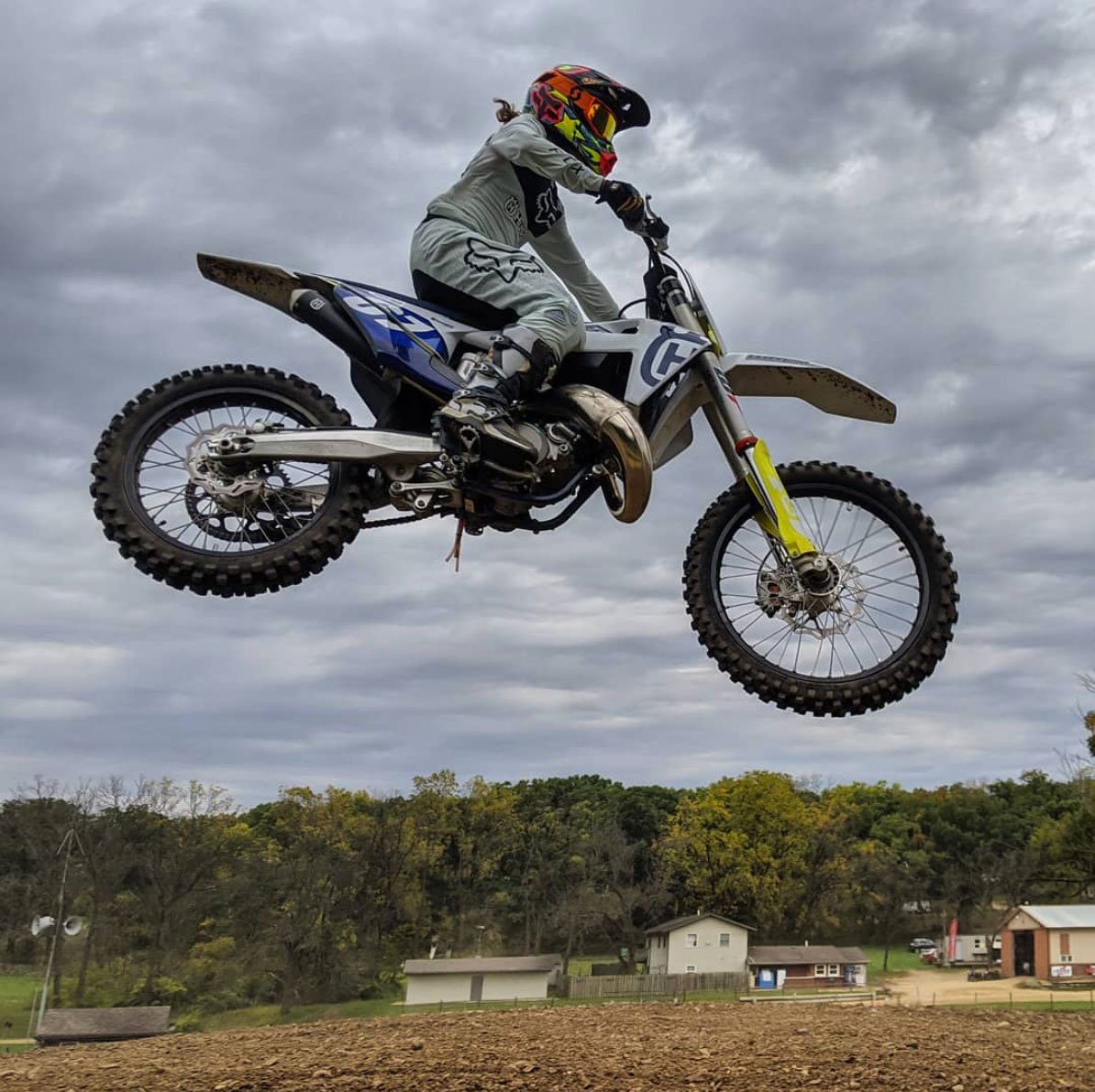 Ashley Fiolek, first deaf motorcross champion, mid jump on her bike with clear ground beneath