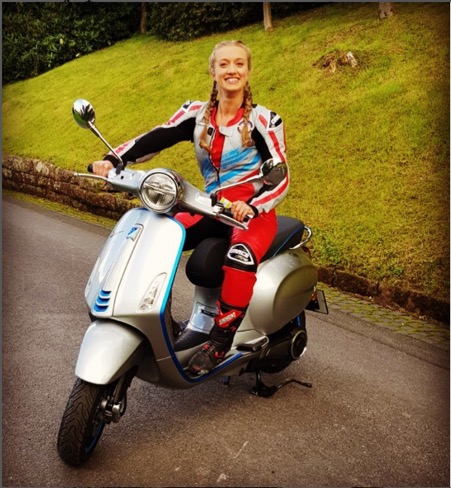 TV present Grace Webb poses on a silver vespa wearing red leathers
