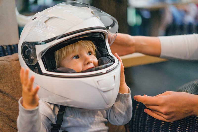 Child wearing adults' motorcycle helmet